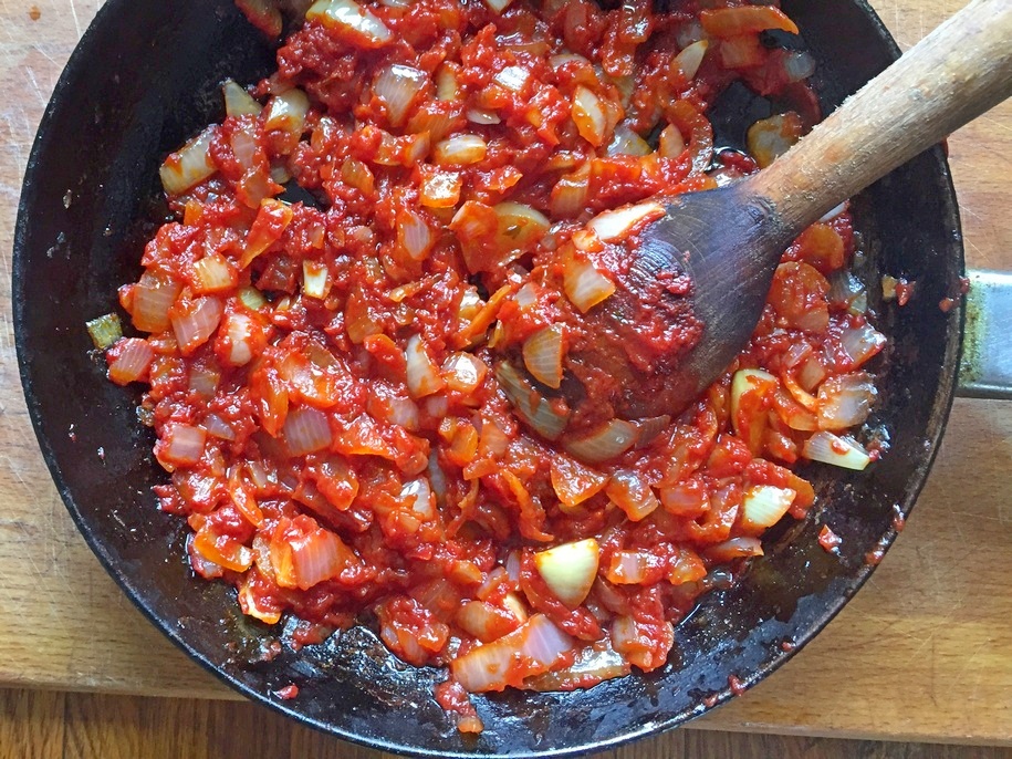 Коли цибуля майже готова, додаємо томатну пасту і, помішуючи, пару хвилин тримаємо її на сковорідці