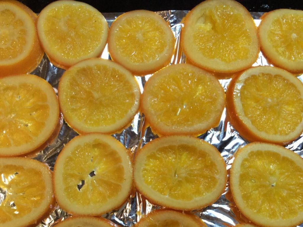 На застелене фольгою деко викладаємо кружальця апельсинів і ставимо в розігріту духовку