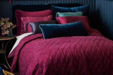 Ліжко із оксамитовими подушками та бордовою ковдрою